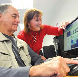 picture of man working at a computer supported by a woman